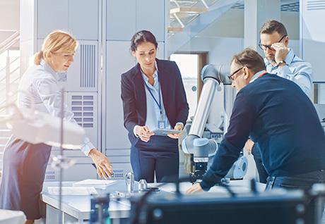 a group of four researchers or engineers around a table are thinking about a problem