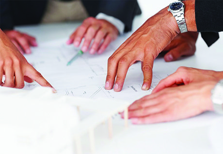 mehrere Hände auf Besprechungstisch.jpg